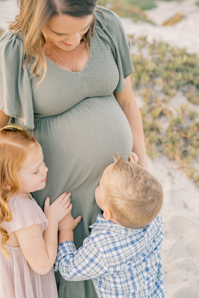 Pregnant mother and her two older children hugging