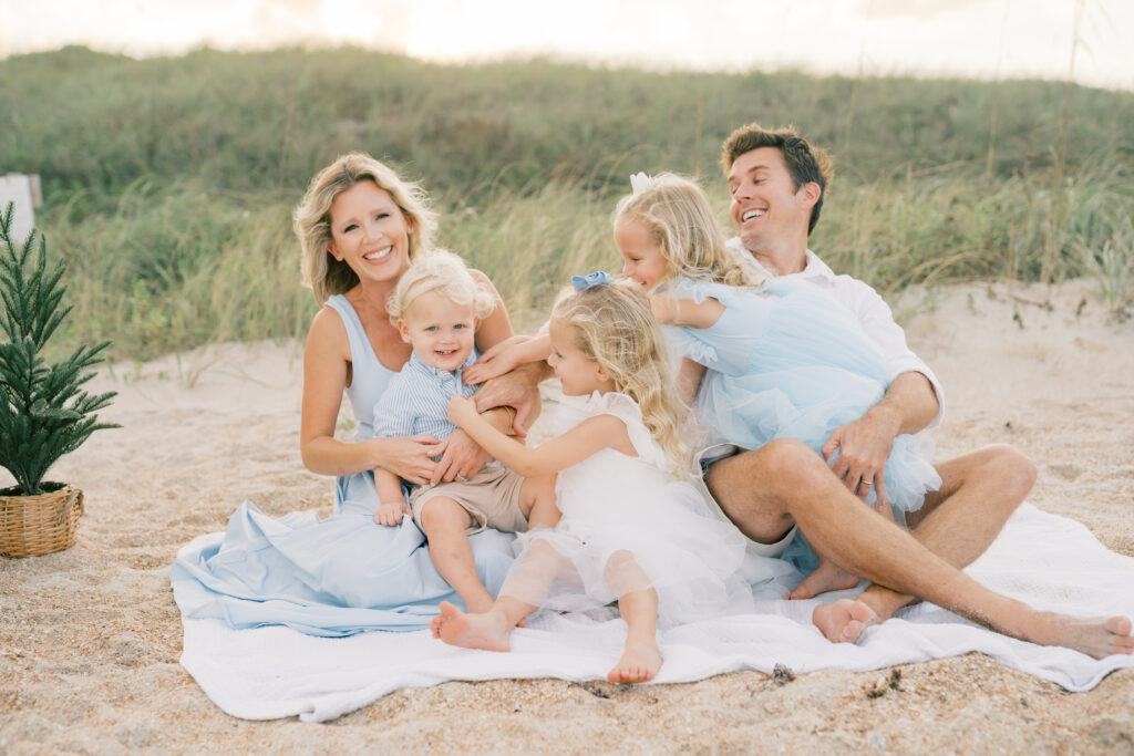 Breece family sitting down on beach at Guana Reserve Middle Beach